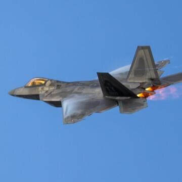 The pressure differentiation produced by the exhaust of the afterburners causes pulsating orange “Shock Diamonds” to stream behind the F-22.
